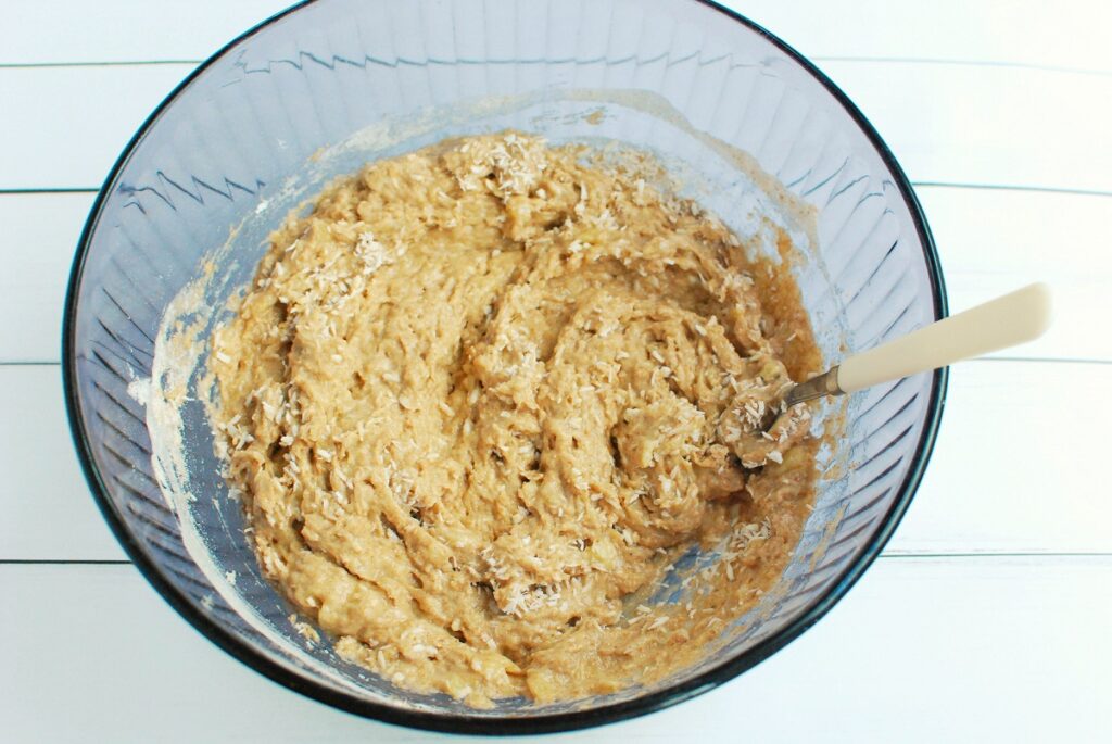 The banana bread batter in a bowl with coconut folded in.