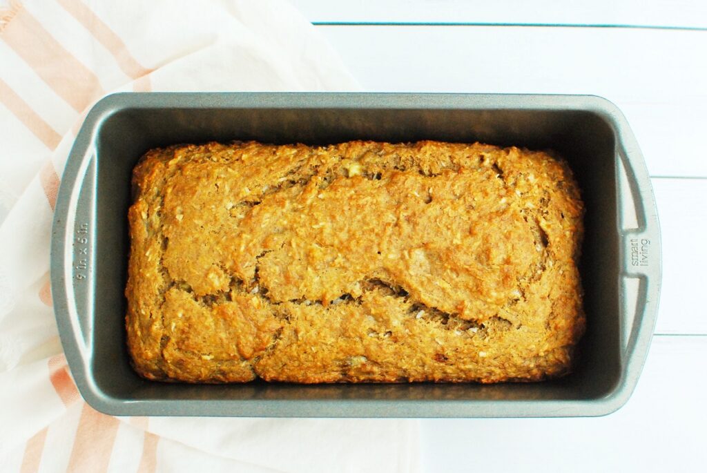 A baked loaf of vegan coconut banana bread in the pan.