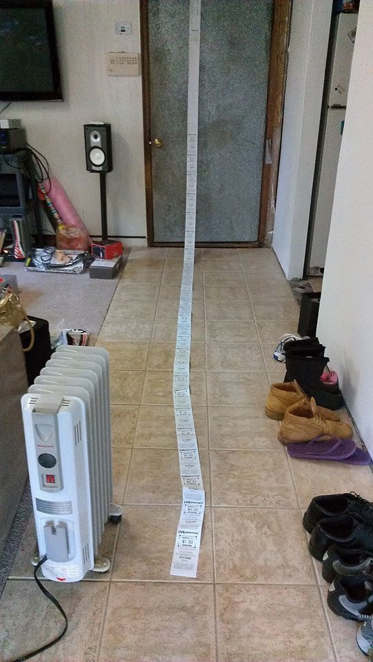 A very long CVS receipt taped to a door.