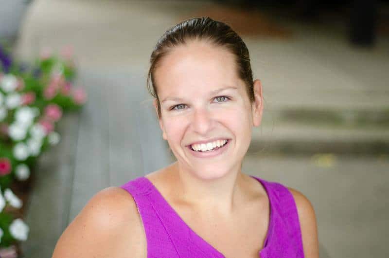 A headshot of Chrissy Carroll in a purple dress outside.