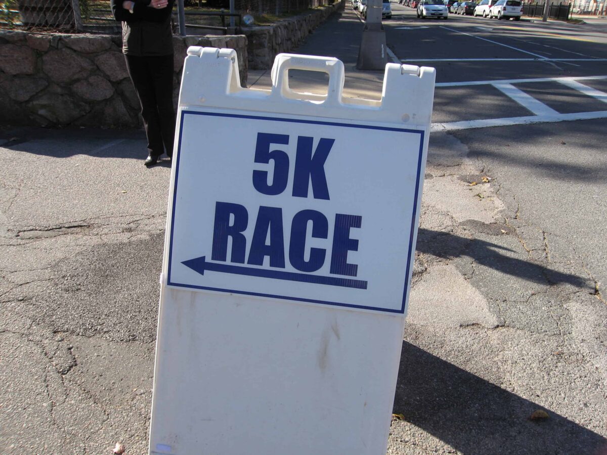 A 5K race sign on the street.