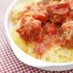 A plate with crockpot spaghetti squash and meatballs topped with tomato sauce