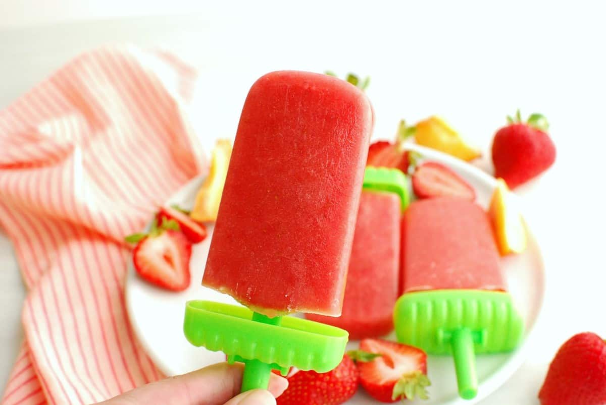 A woman's hand holding a popsicle.