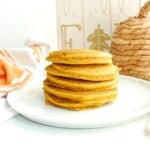 A stack of whole wheat pumpkin pancakes on a white plate.