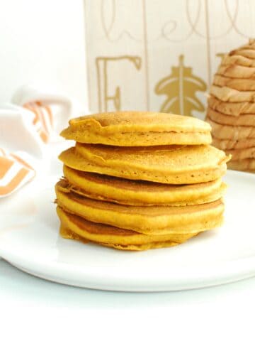 A stack of whole wheat pumpkin pancakes on a white plate.