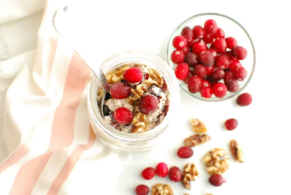 Overhead shot of overnight oats with cranberries and walnuts on top.