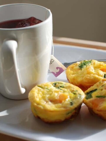 Veggie egg muffins on a plate next to tea