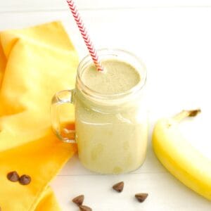 A mason jar filled with a banana peanut butter spinach chocolate smoothie to drink after a workout.