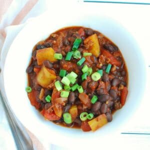 A bowl of chipotle chili topped with scallions.