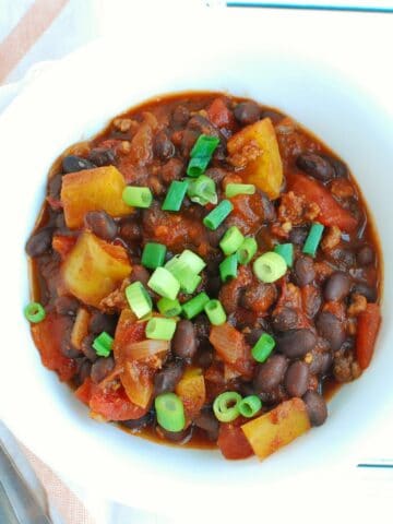 A bowl of chipotle chili topped with scallions.