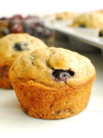 A close up of a whole wheat banana blueberry muffin.