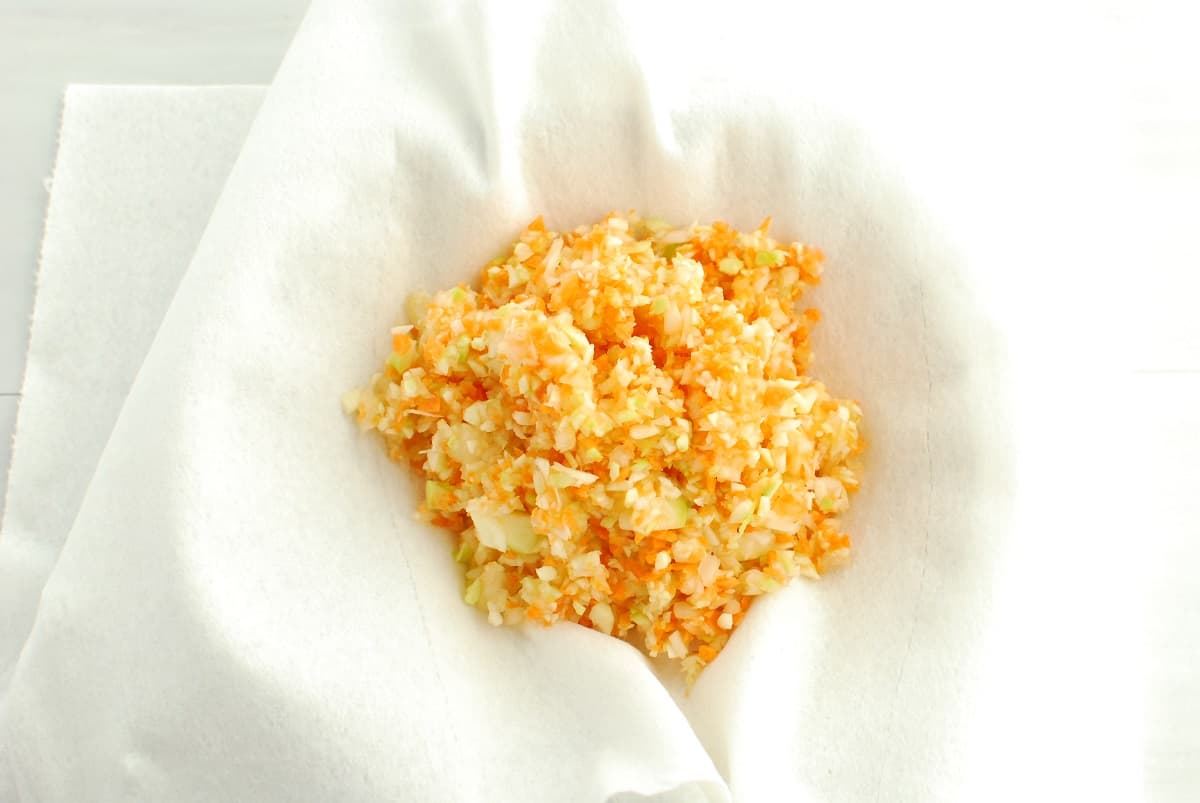 Shredded vegetables in a paper towel lined bowl.