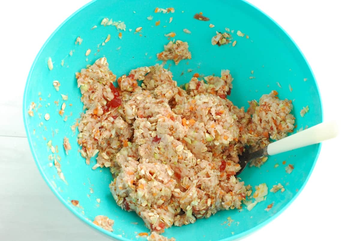 All the ingredients for meatloaf combined in a mixing bowl.