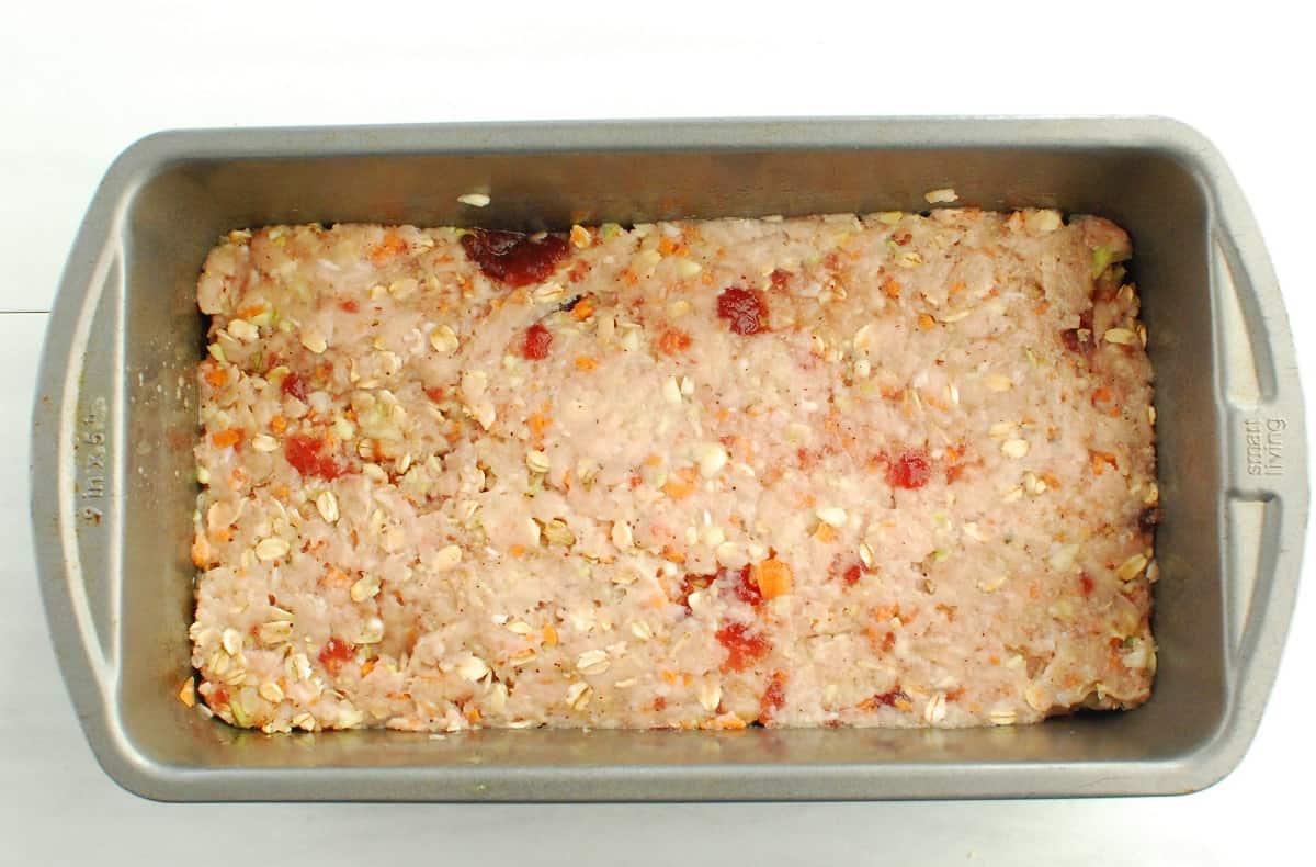 A loaf pan with uncooked meatloaf.