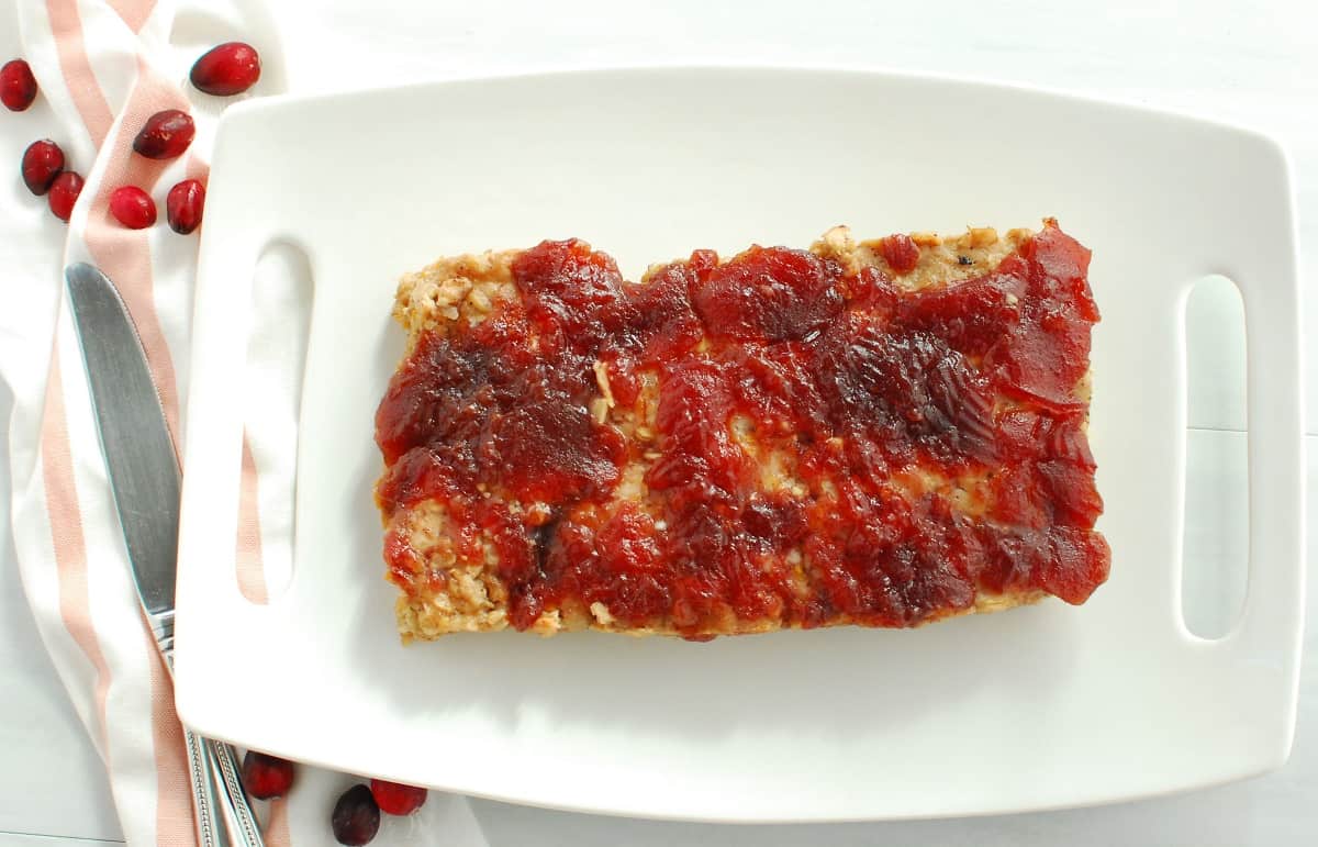 A cooked meatloaf on a white plate.