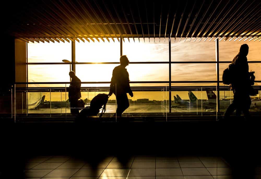 People walking by the window at the airport