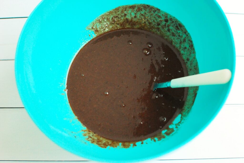 A bowl with the brownie batter after adding the melted dark chocolate.