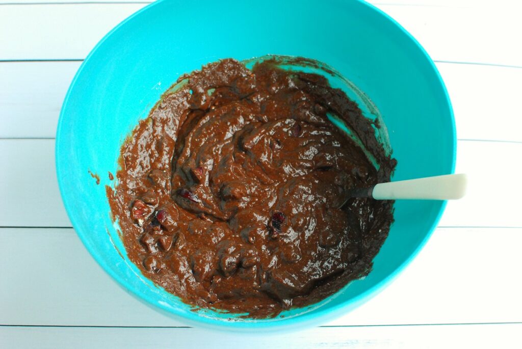 A bowl with the fully mixed brownie batter with cherries folded in.