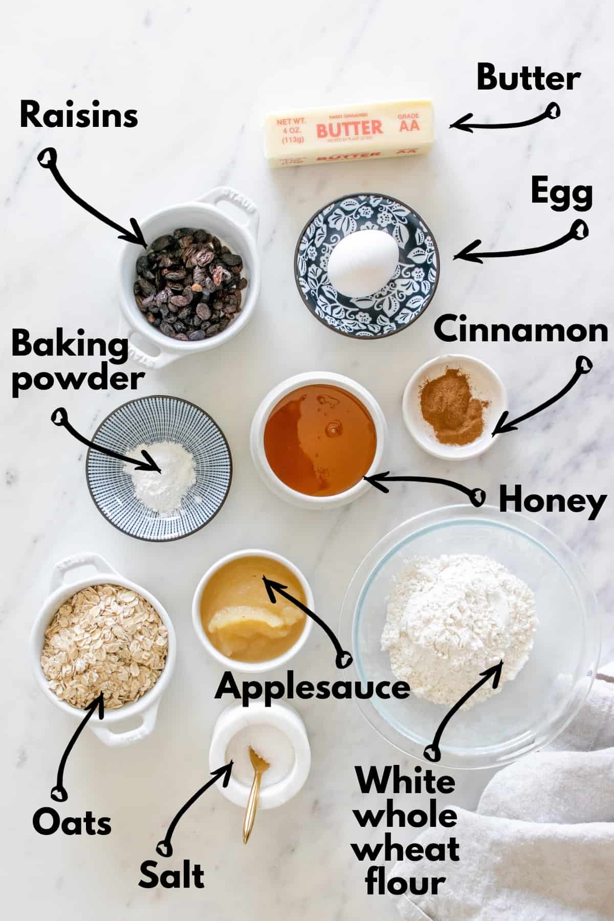 All of the cookie ingredients spread out on a countertop next to a kitchen towel.