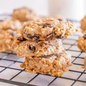 Three healthy oatmeal raisin cookies on a cooling rack.