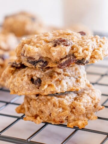 Three healthy oatmeal raisin cookies on a cooling rack.