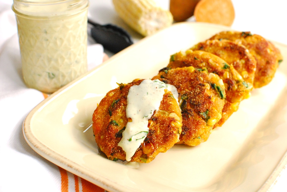 A sweet potato corn fritter drizzled with garlic cilantro aquafaba aioli.