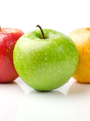 A green apple, a red apple, and a yellow apple.
