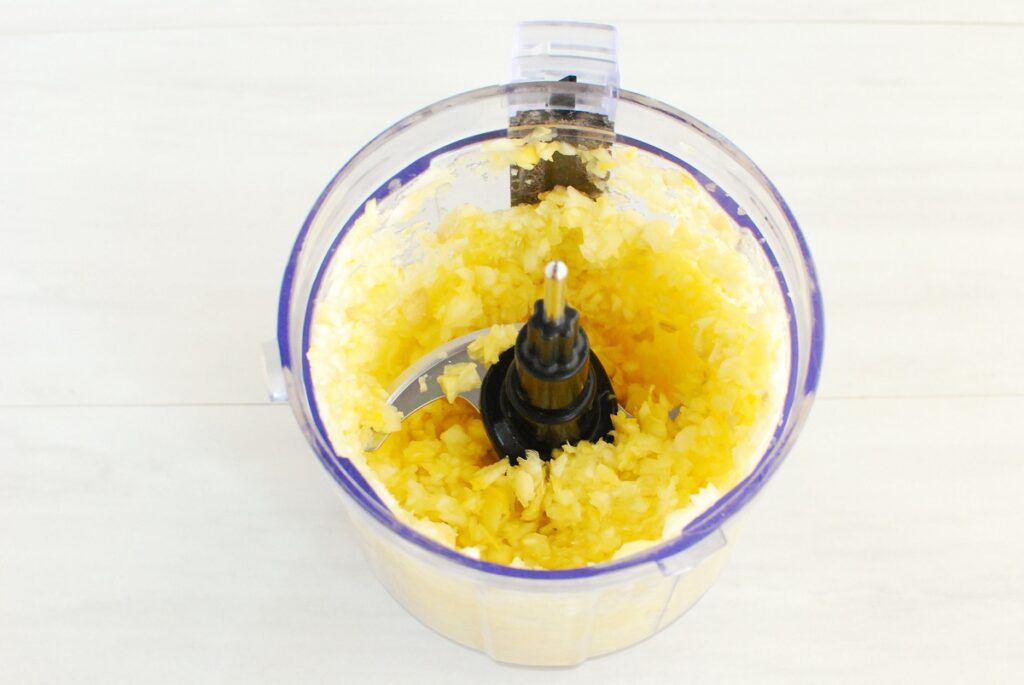 Yellow squash that's been grated in a small food processor.