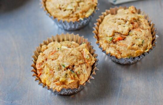 Zucchini apple carrot muffins on a table.