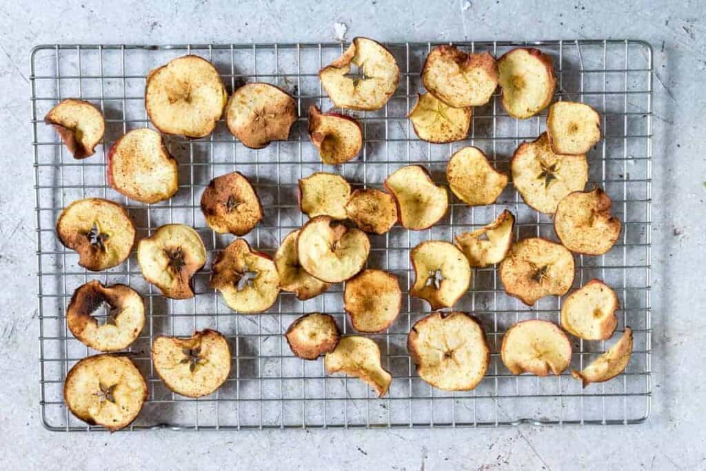 Air fryer apple chips on a cooling rack.