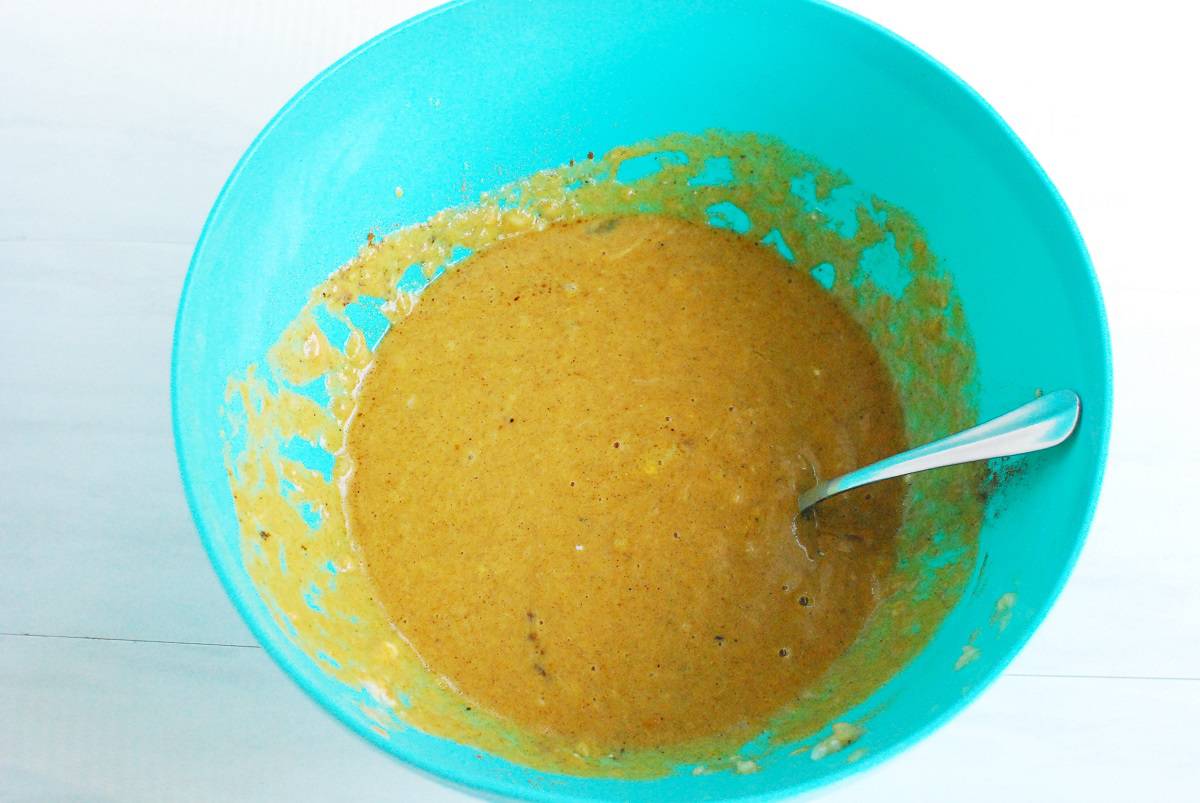 Banana, pumpkin, yogurt, honey, oil, eggs, vanilla, and pumpkin spice mixed together in a bowl.