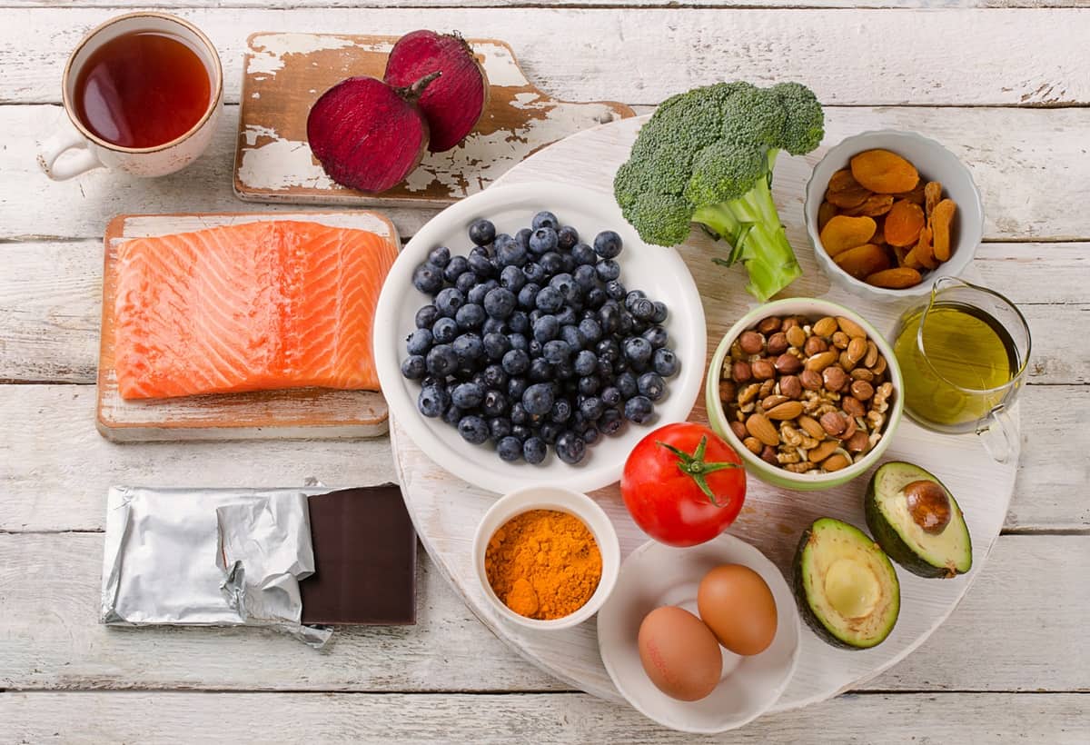 A table with anti inflammatory foods for injuries like fish, dark chocolate, berries, and turmeric.