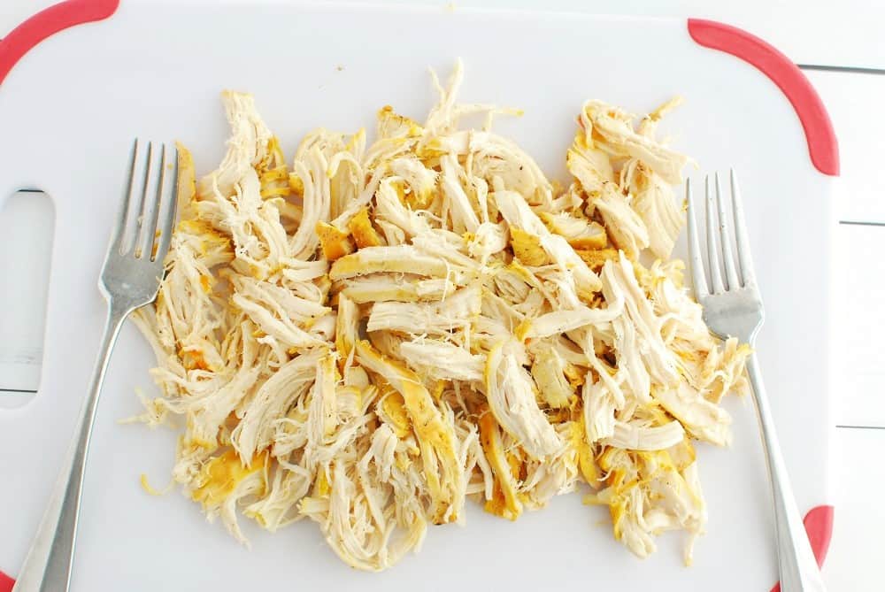 Shredded chicken on a cutting board.