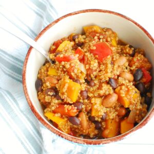 A bowl with butternut squash quinoa chili next to a napkin.