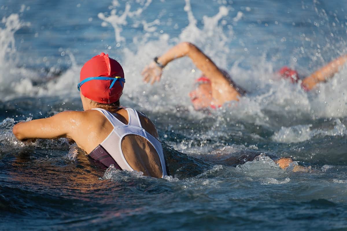 Women swimming in swimsuits in a triathlon race.