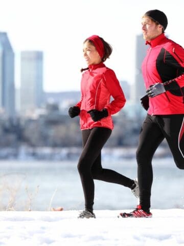 Two runners jogging outside in the winter.