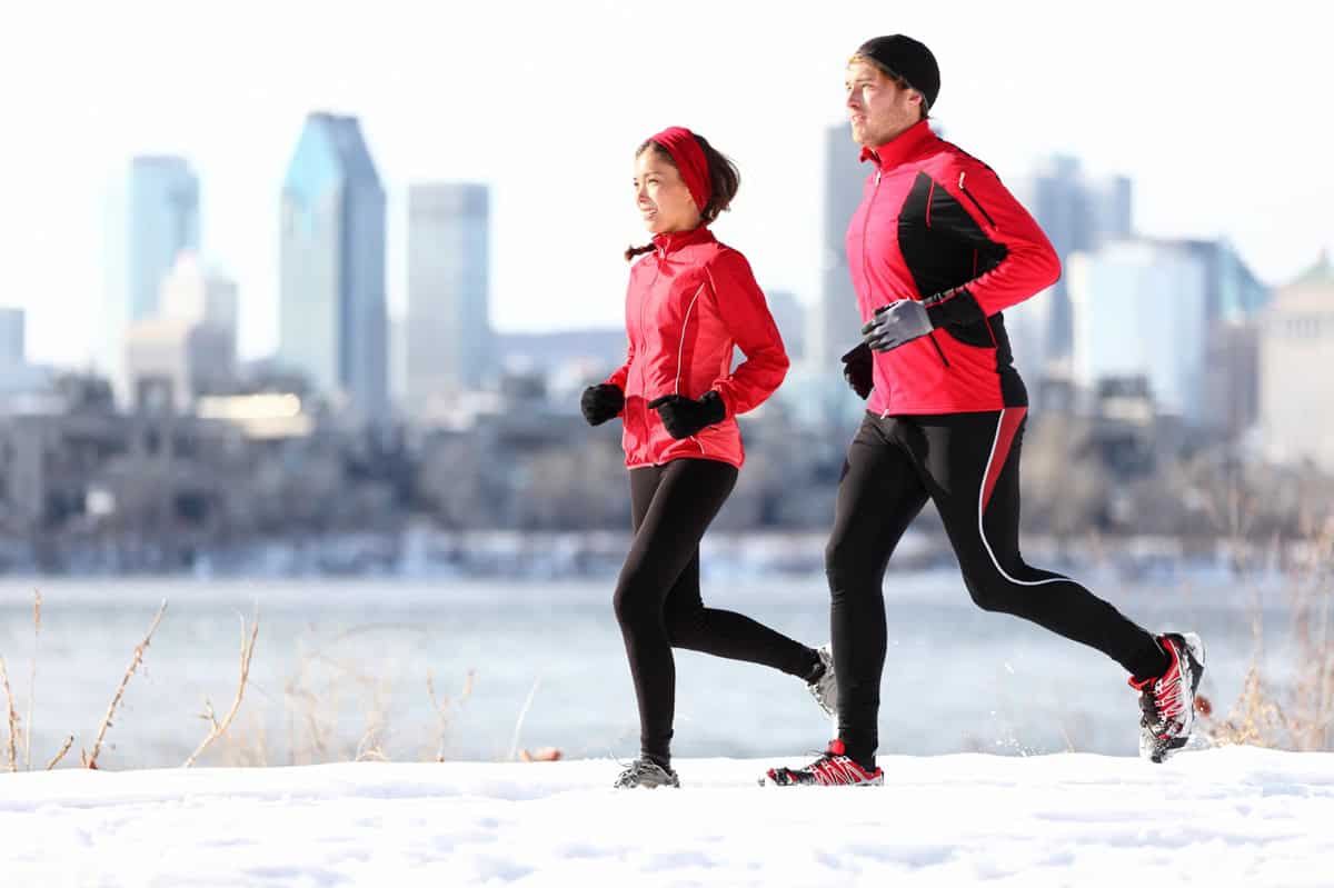 Two runners jogging outside in the winter.