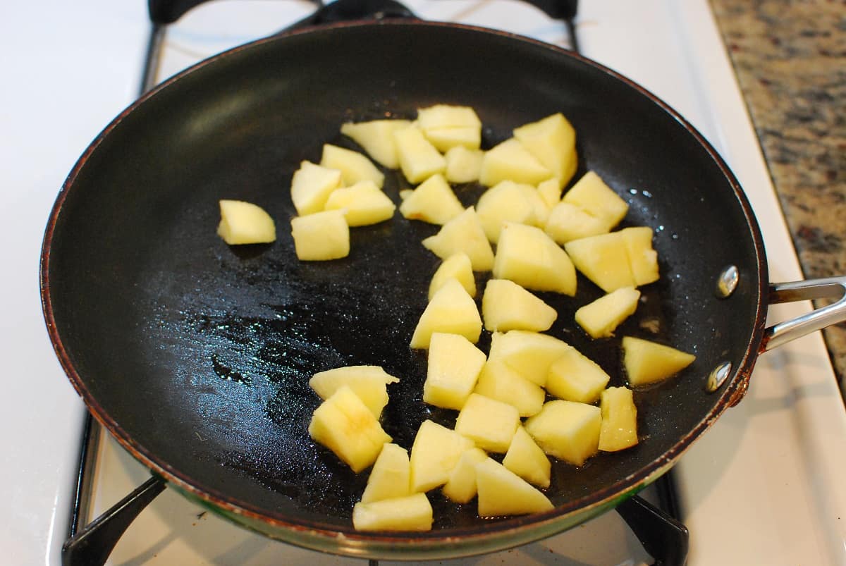 Apples being sautéed in a skillet.