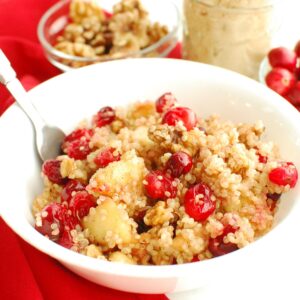 A cranberry apple quinoa breakfast bowl with a spoon in it.