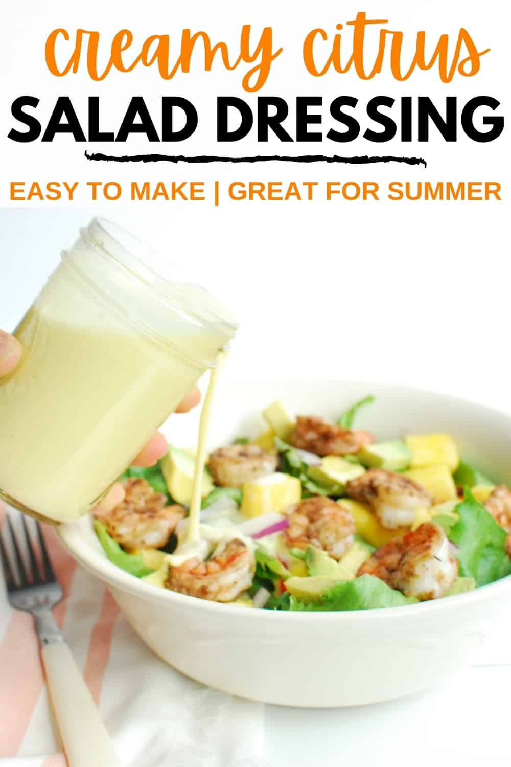 A woman pouring citrus salad dressing over a shrimp salad.