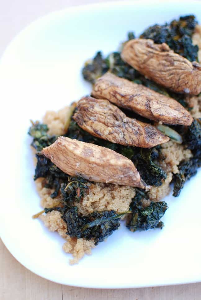 A plate filled with honey balsamic chicken over kale and amaranth.