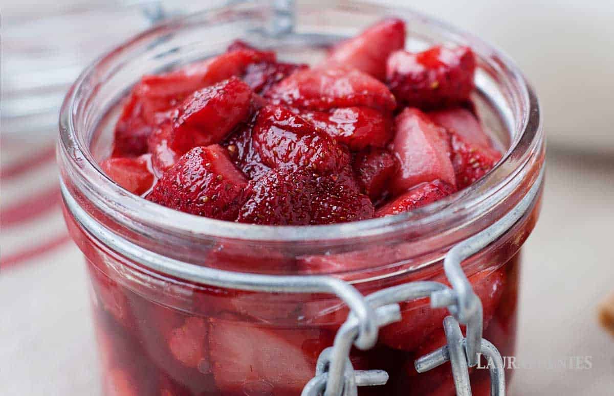 A mason jar full of roasted strawberries.