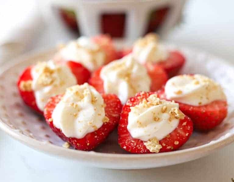 Cheesecake strawberries on a white plate.