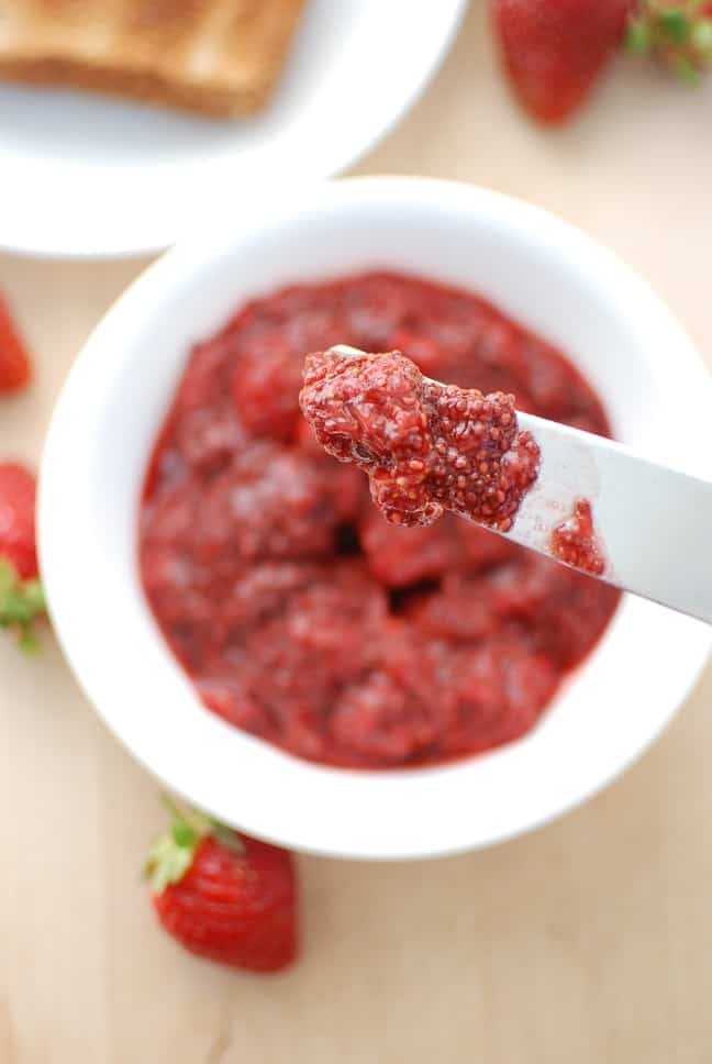 A knife with strawberry chia seed jam on it.