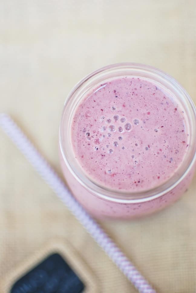 Chocolate cherry smoothie in a mason jar, with a straw next to it