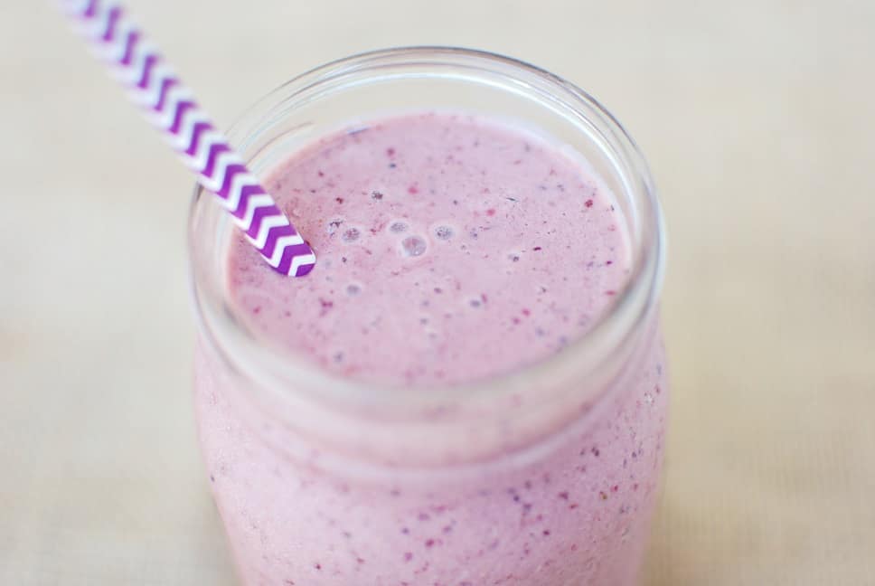 Chocolate cherry smoothie in a mason jar with a purple straw
