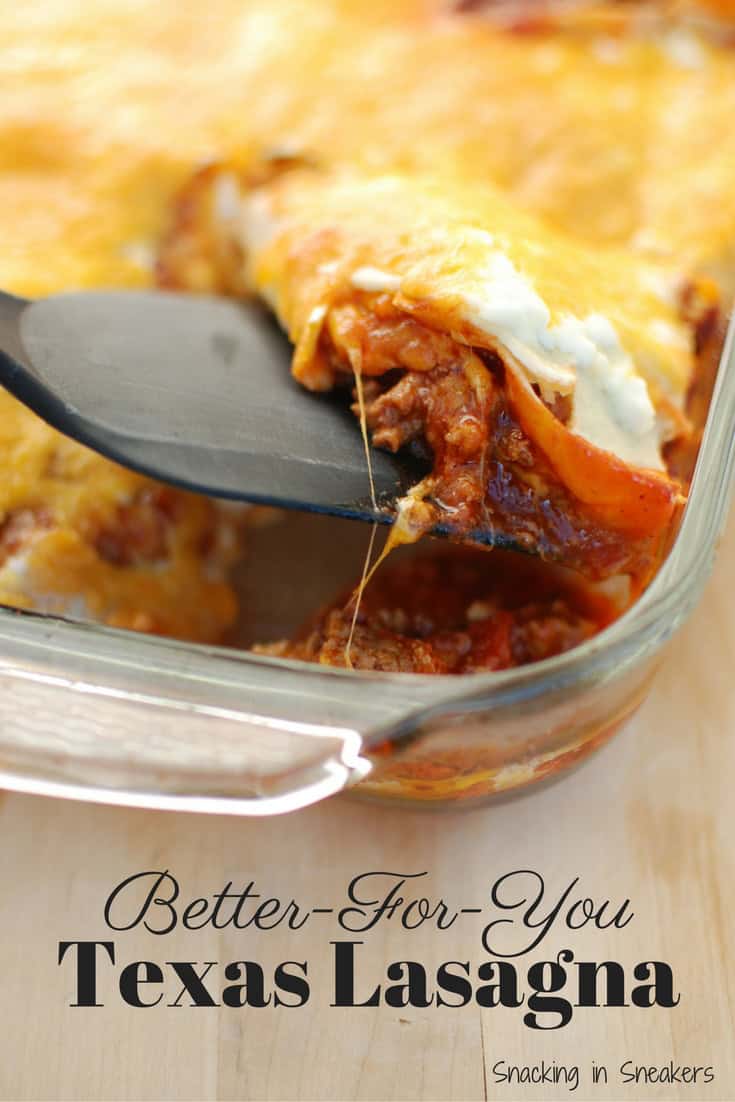 A casserole dish filled with Texas lasagna with a spatula taking a piece out.