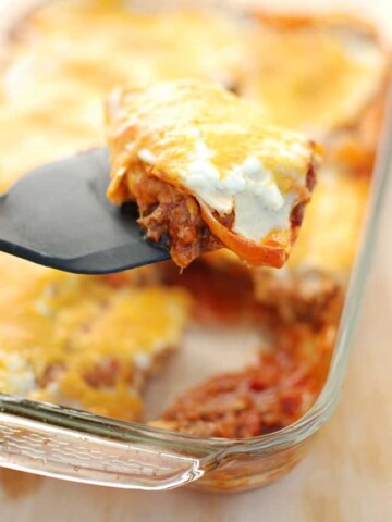 Texas lasagna is a southwestern style casserole recipe – flavors like chili powder and paprika are used to season the meat, corn tortillas take the place of lasagna noodles, and cheddar replaces mozzarella. This healthy version is under 500 calories per serving yet still tastes rich and indulgent!