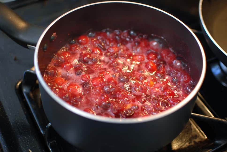 Healthy fresh cranberry sauce cooking in a pot on the stove