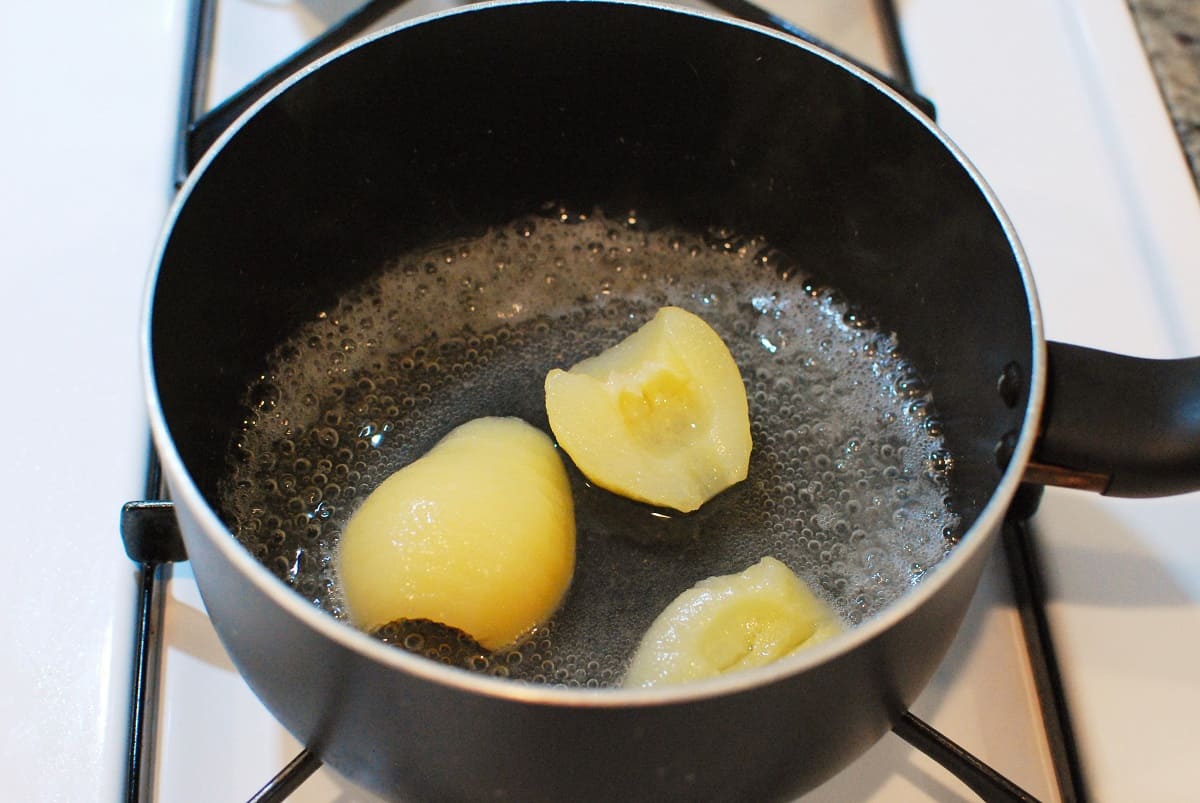 Canned pears and pear juice in a pot.